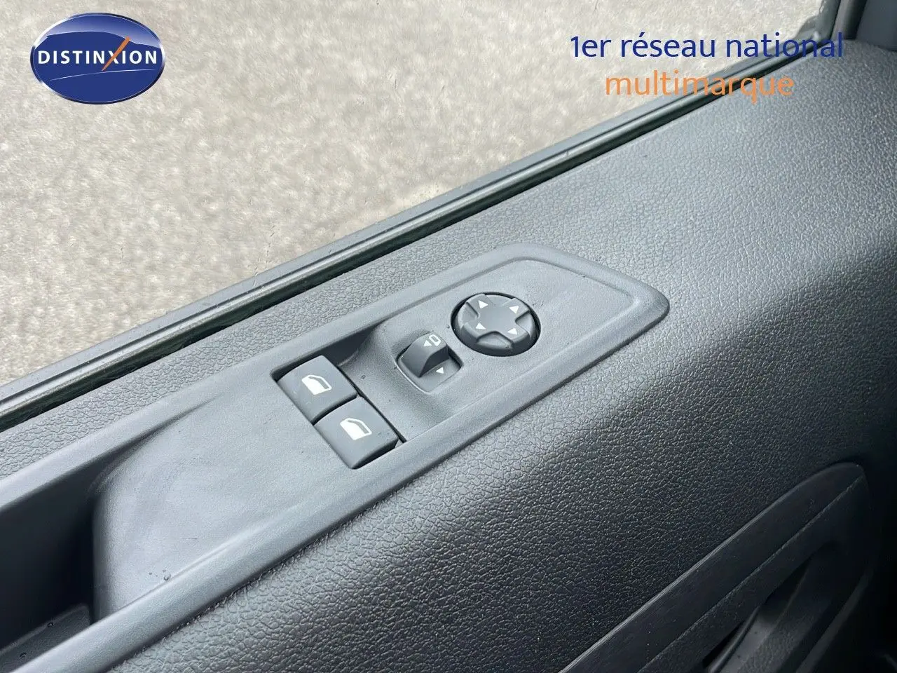 Gros plan sur les commandes de lève-vitres et réglage des rétroviseurs côté conducteur du Peugeot Expert Fourgon blanc 2025.