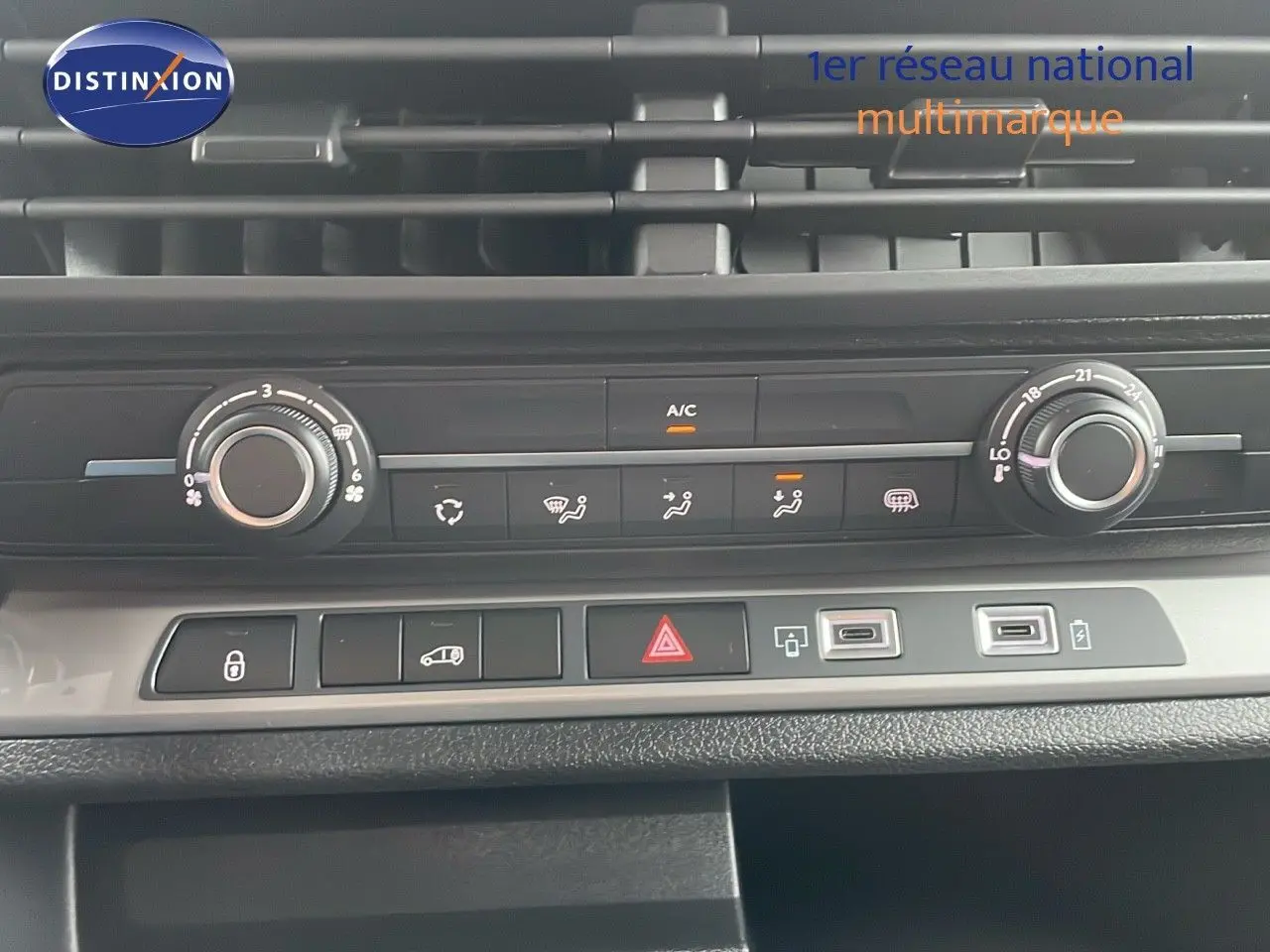 Vue rapprochée de la console centrale du Peugeot Expert Fourgon blanc 2025, montrant les commandes de climatisation et boutons fonctionnels.