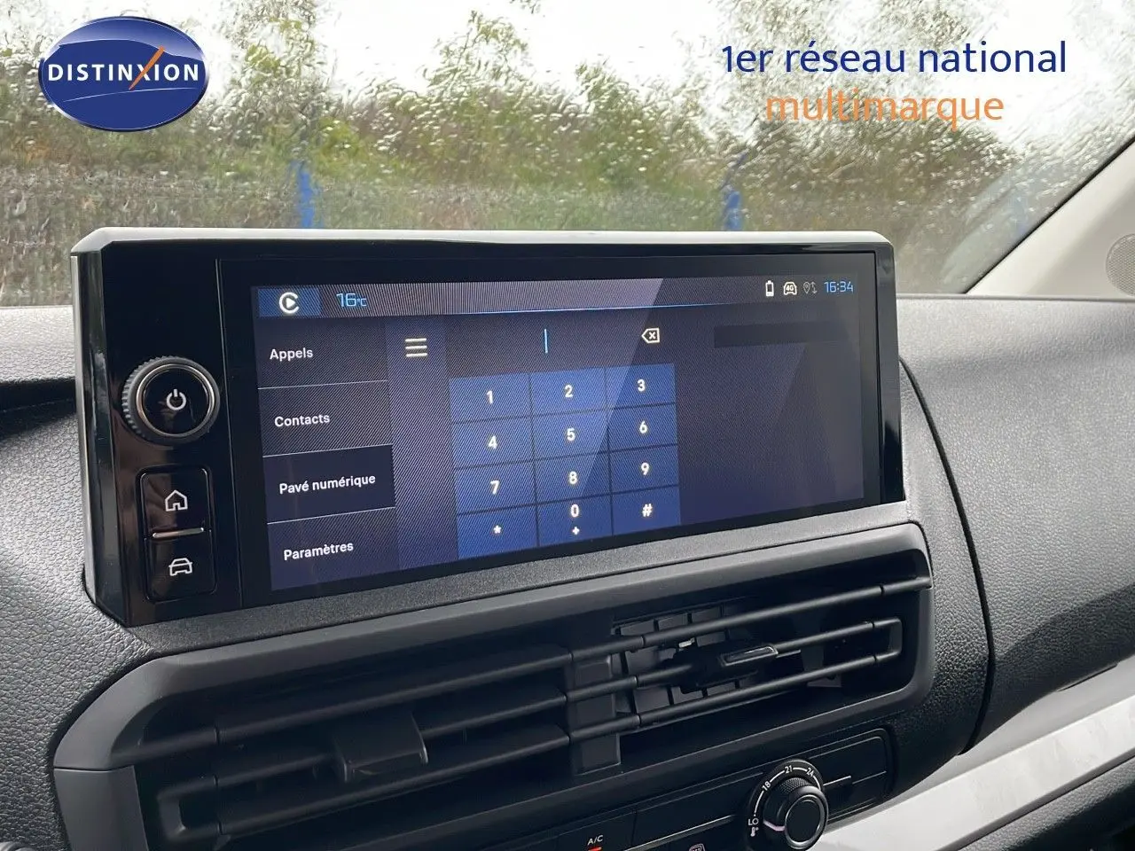 Écran tactile central du tableau de bord du Peugeot Expert Fourgon blanc, avec commandes numériques et ventilation visible.