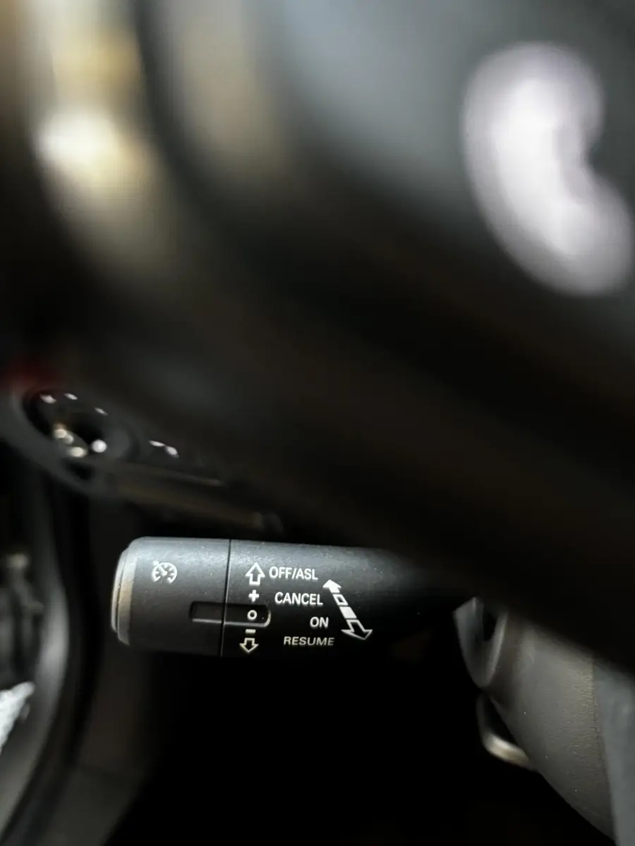 Gros plan sur la commande de régulateur de vitesse dans l’habitacle du MG ZS gris clair, version 2022.