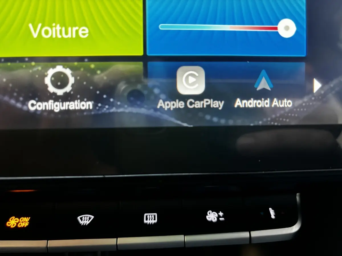 Gros plan sur l'écran tactile central du MG ZS 2022, affichant Apple CarPlay et Android Auto, avec commandes climatisation en dessous.