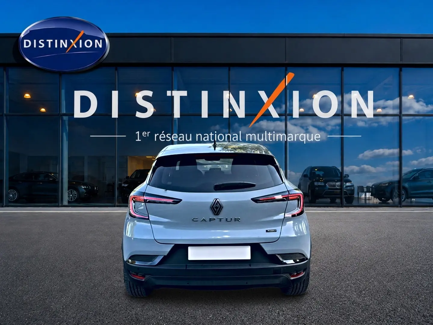 Vue arrière du Renault Captur gris rafale 2026, avec feux arrière LED et logo distinctif visible devant un showroom Distinxion.
