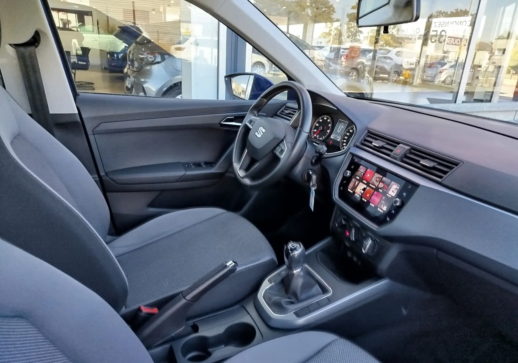 Intérieur de la SEAT Arona 2019 vu côté conducteur, avec tableau de bord moderne et boîte manuelle noire.