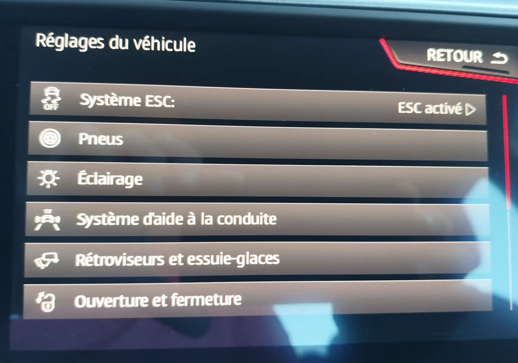Écran tactile du système de réglages du véhicule SEAT Arona 2019, affichant les options d'aide à la conduite et d'éclairage.