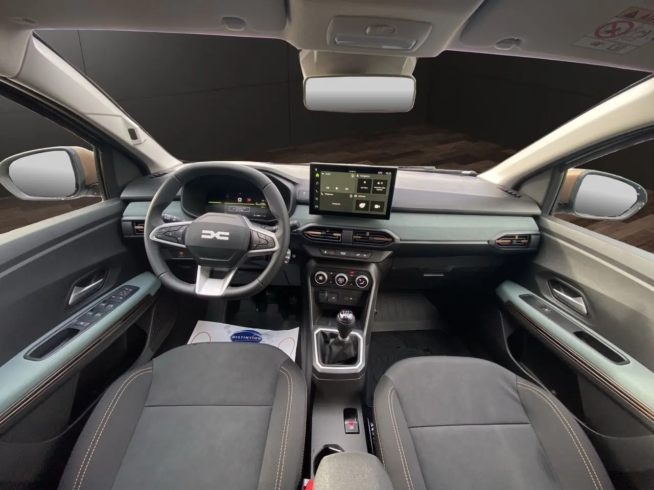 Vue intérieure avant du tableau de bord et des sièges tissu gris noir du Dacia Sandero Stepway TCE 110 Extreme 2026.