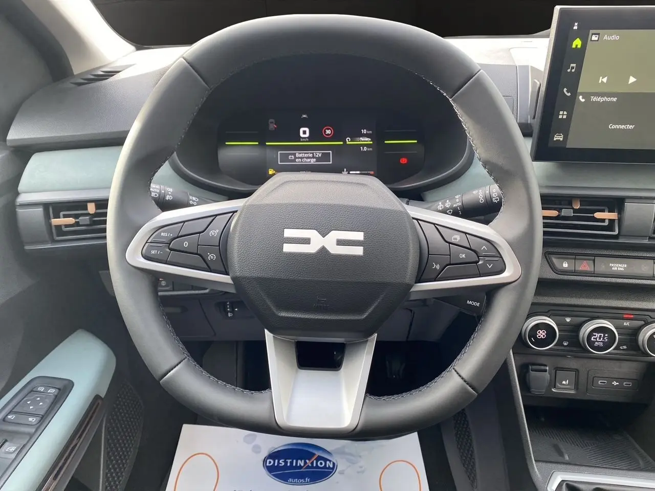 Vue intérieure centrée sur le volant multifonction noir et gris du Dacia Sandero Stepway avec tableau de bord digital et écran tactile.