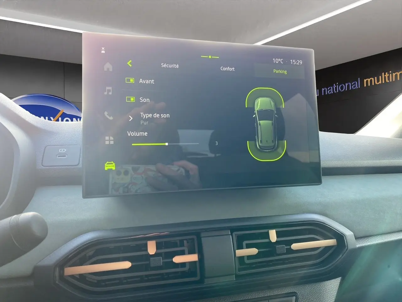 Écran tactile central affichant les réglages de sécurité et parking dans l’habitacle gris clair du Dacia Sandero Stepway.