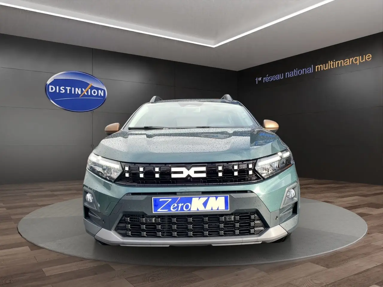 Vue frontale d'une Dacia Sandero Stepway 2026 vert cèdre avec calandre noire et logo DACIA lumineux.