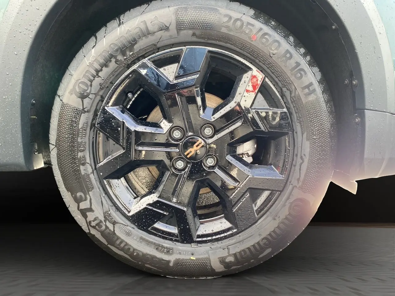 Gros plan sur la jante alliage noire 16 pouces Tamia Black d'une Dacia Sandero Stepway Vert Cèdre avec pneu Continental.