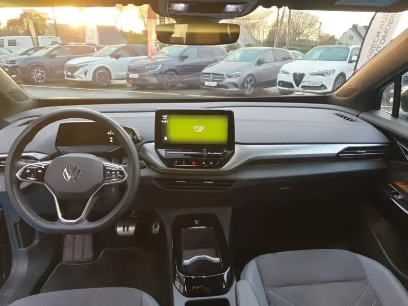 Vue intérieure avant du Volkswagen ID.4 148ch Pure 52 kWh Life Plus noir, avec tableau de bord moderne et écran tactile central.