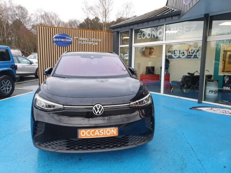 Volkswagen ID.4 noir Ebène métallisé vu de face, avec calandre lisse et logo VW central lumineux.