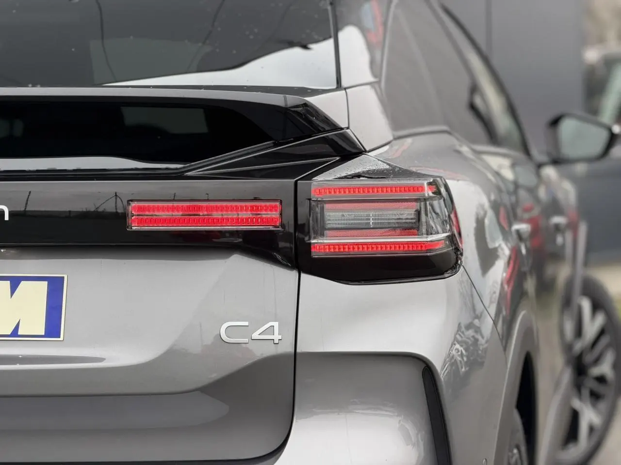 Vue arrière droite d'une Citroën C4 gris Mercury avec feux arrière LED et toit bi-ton noir Perla Nera.