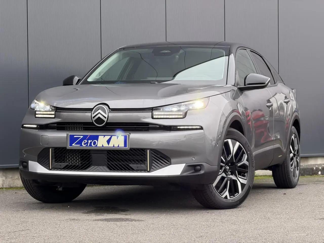 Citroën C4 NV Hybrid gris Mercury en 3/4 avant droit avec toit bi-ton noir et jantes alliage 18 pouces.