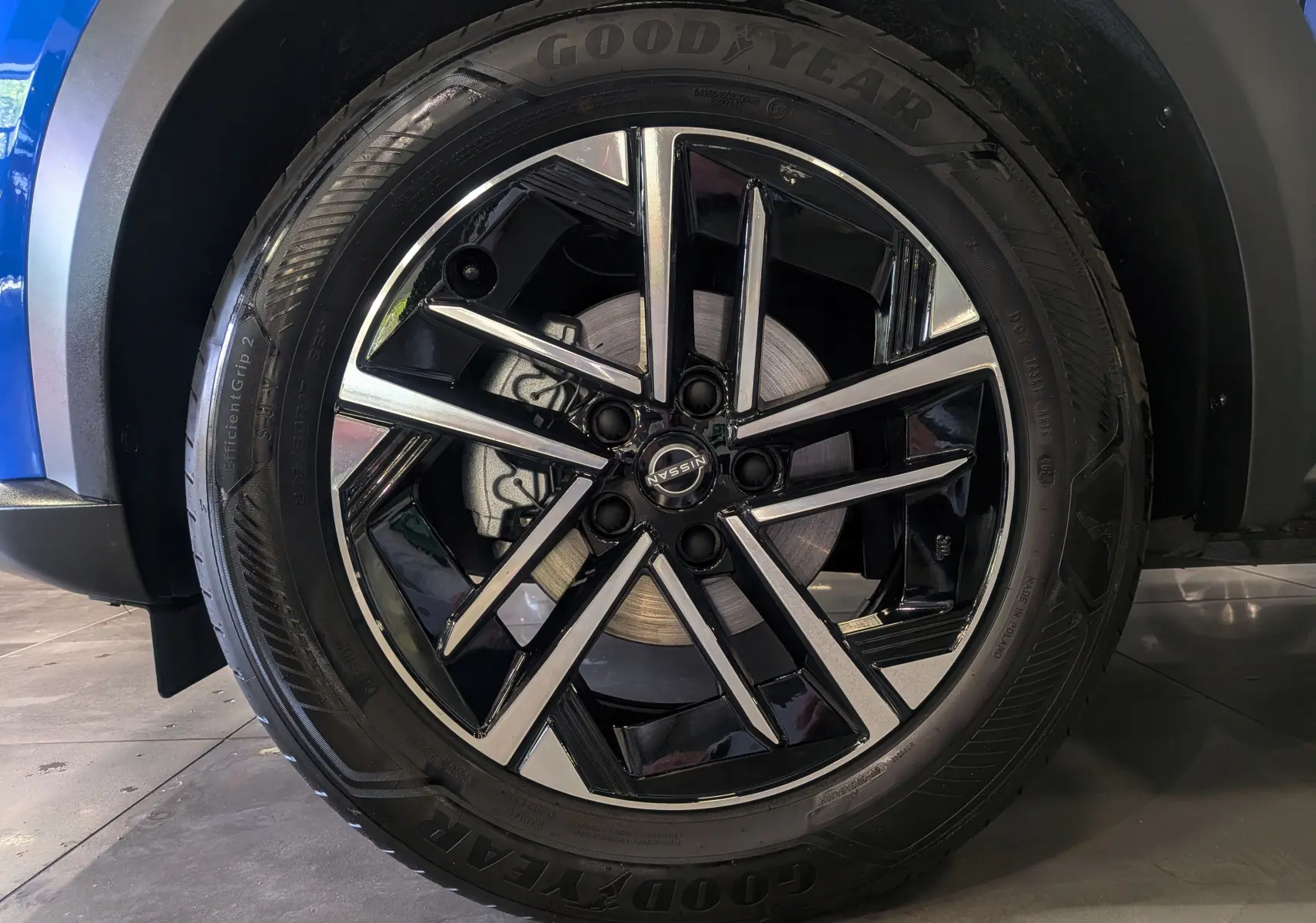 Gros plan sur la roue avant droite du Nissan Juke Hybrid 2025, jante noire et argent avec pneu Goodyear.