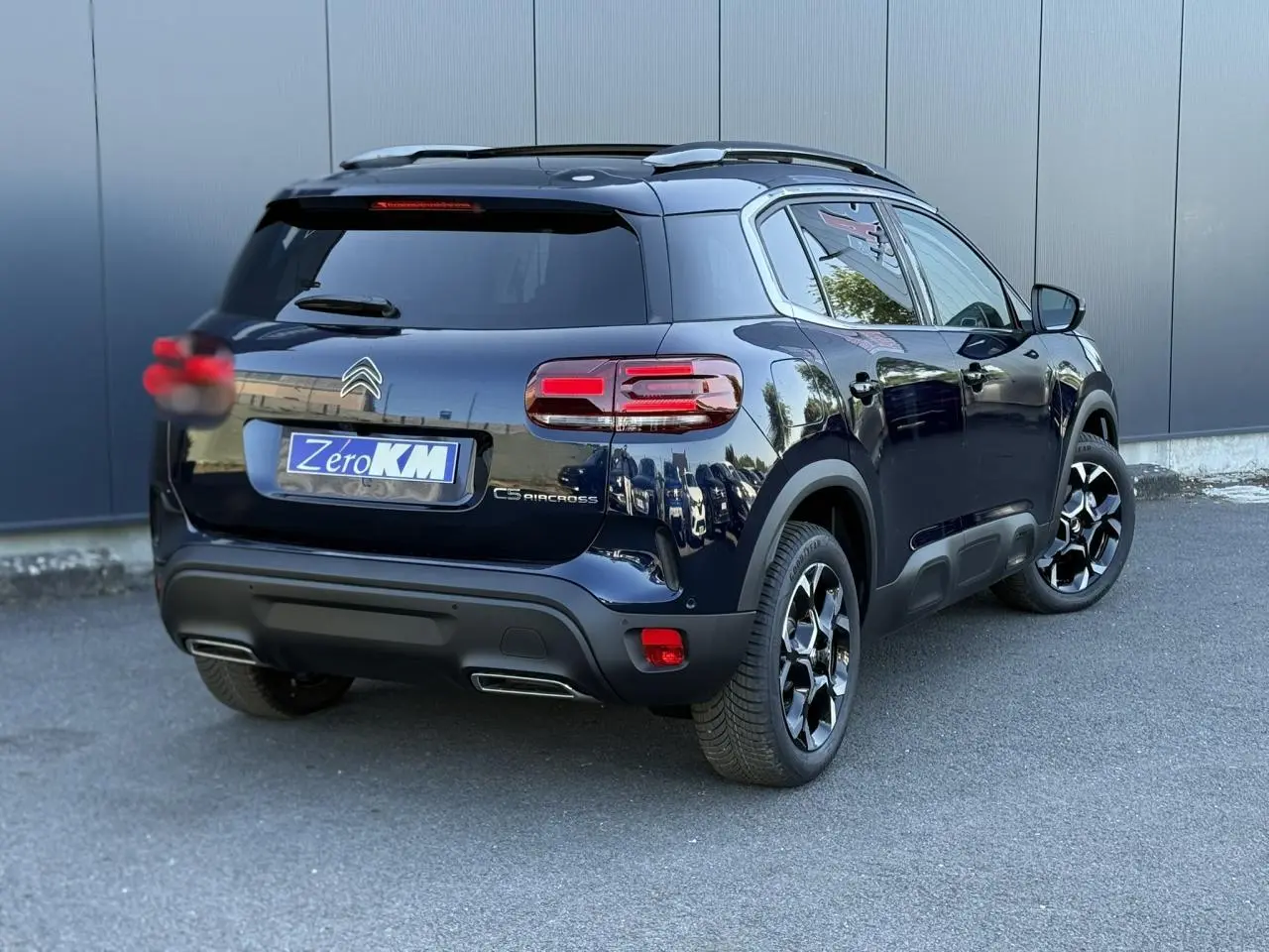 Vue 3/4 arrière droite d'un Citroën C5 Aircross Bleu Eclipse avec jantes alliage bi-ton et hayon électrique.