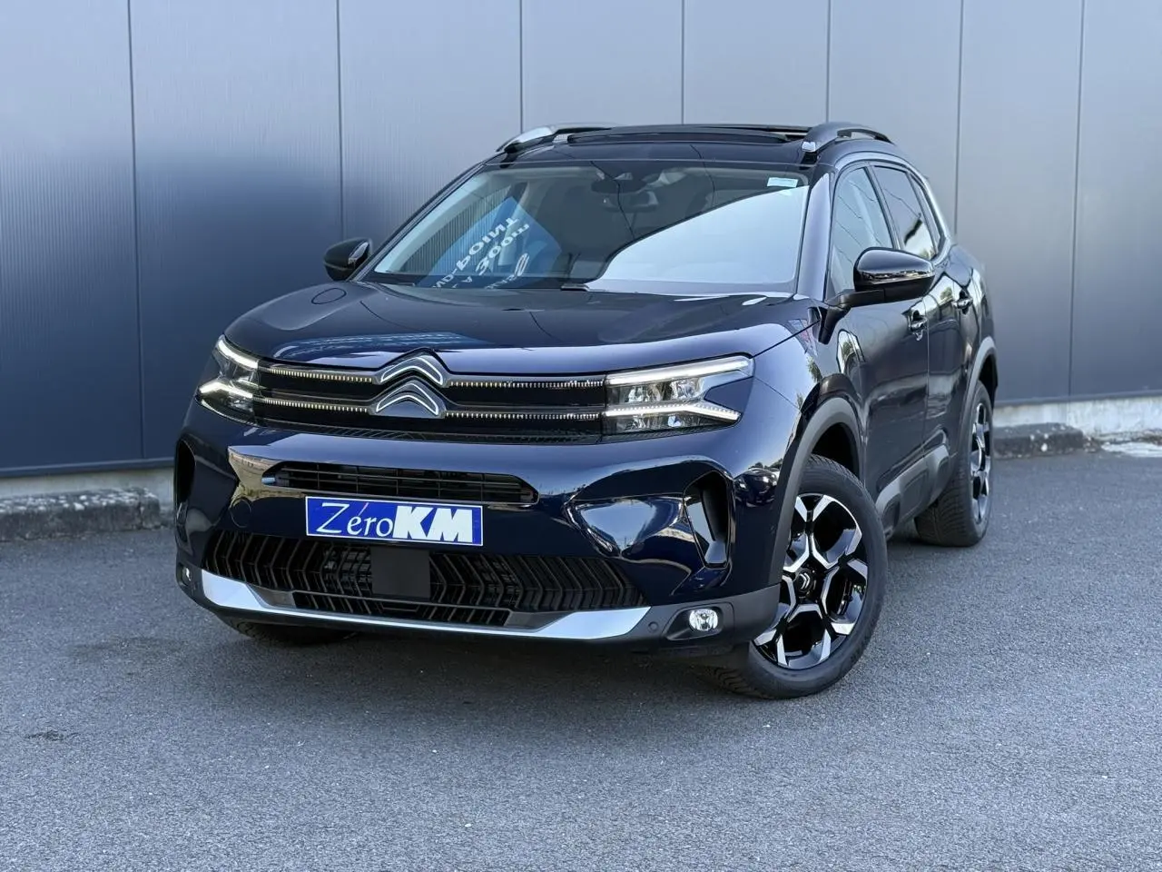 Vue 3/4 avant droite d'un Citroën C5 Aircross Bleu Eclipse avec jantes alliage bi-ton et toit ouvrant panoramique.
