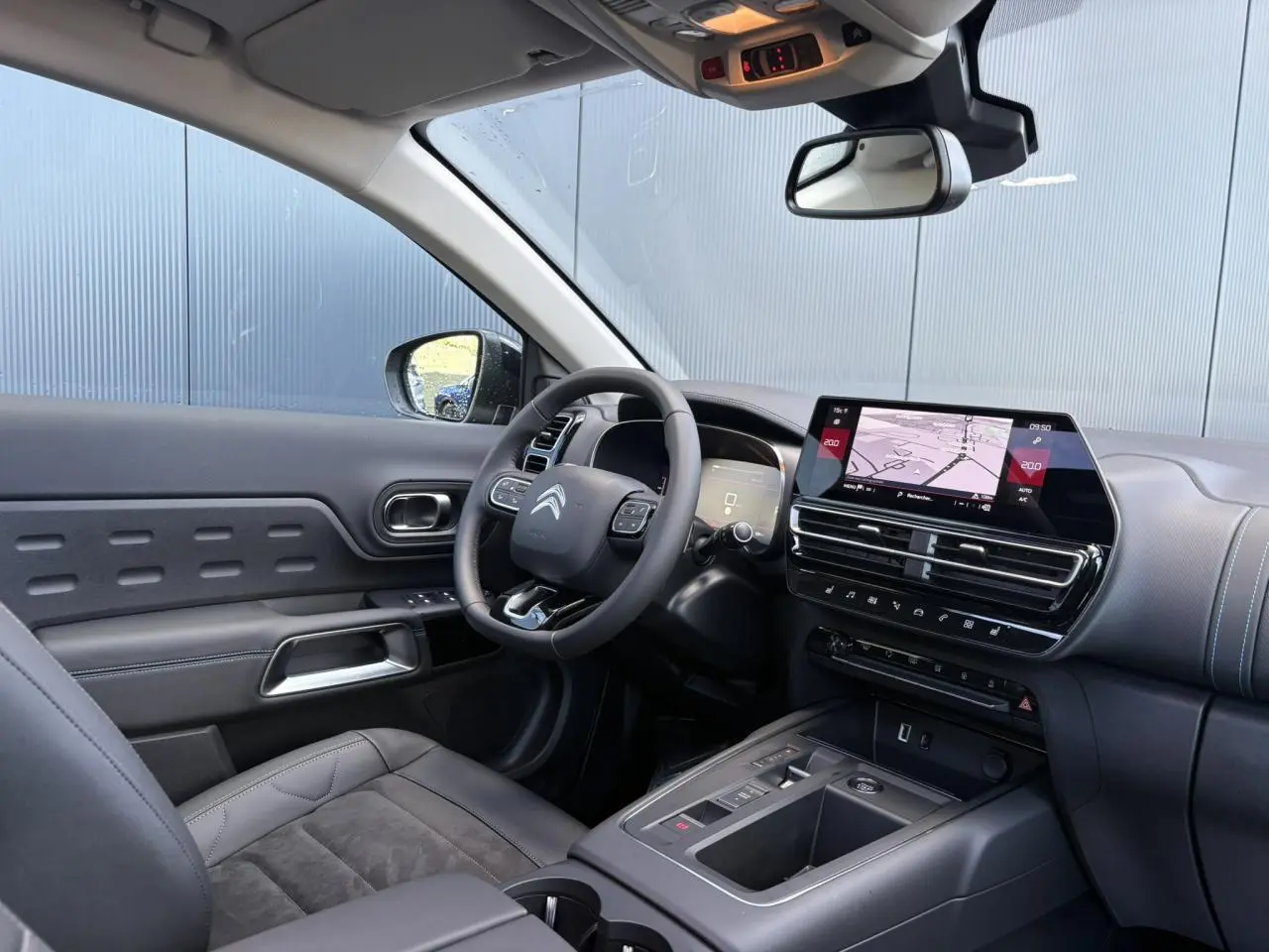 Intérieur du Citroën C5 Aircross 2025 en vue côté conducteur, avec tableau de bord numérique et sièges Alcantara noirs.