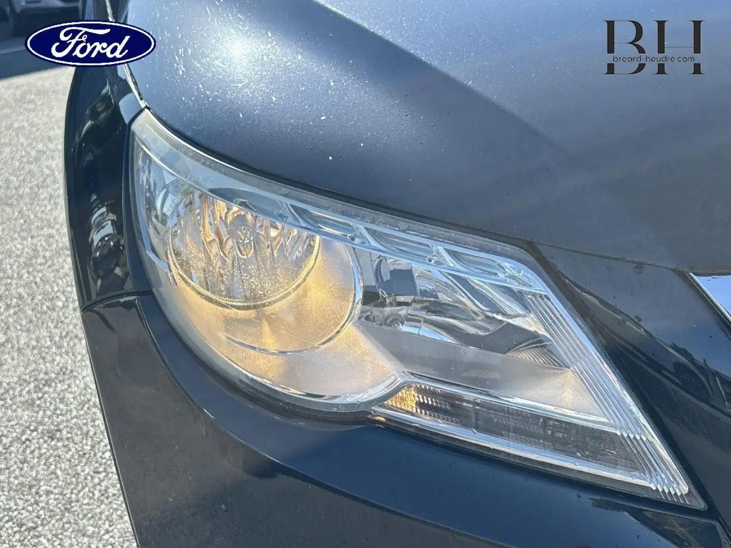 Gros plan sur le phare avant droit d’un Volkswagen Tiguan beige, mettant en valeur les détails du bloc optique et la carrosserie.