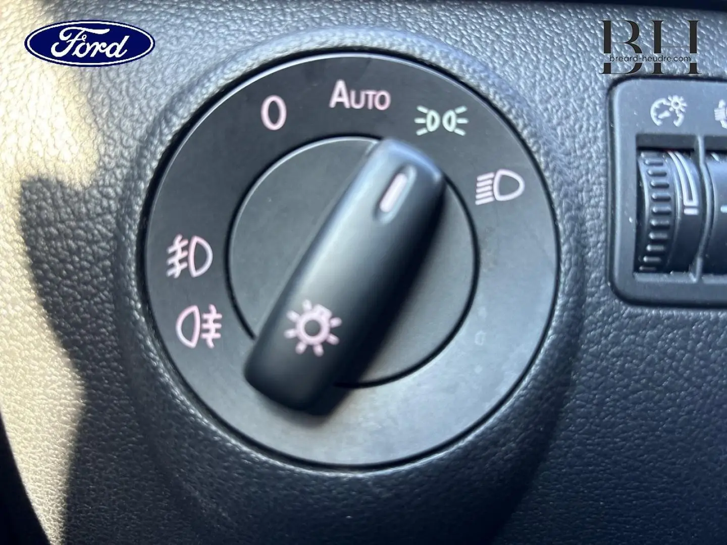 Commande des phares en gros plan sur tableau de bord noir d'un Volkswagen Tiguan beige 2010, version 1.4 TSI Carat.