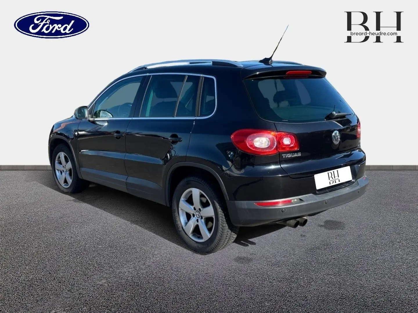 SUV Volkswagen Tiguan noir en 3/4 arrière droit, avec jantes alu et vitres teintées, sur fond neutre.