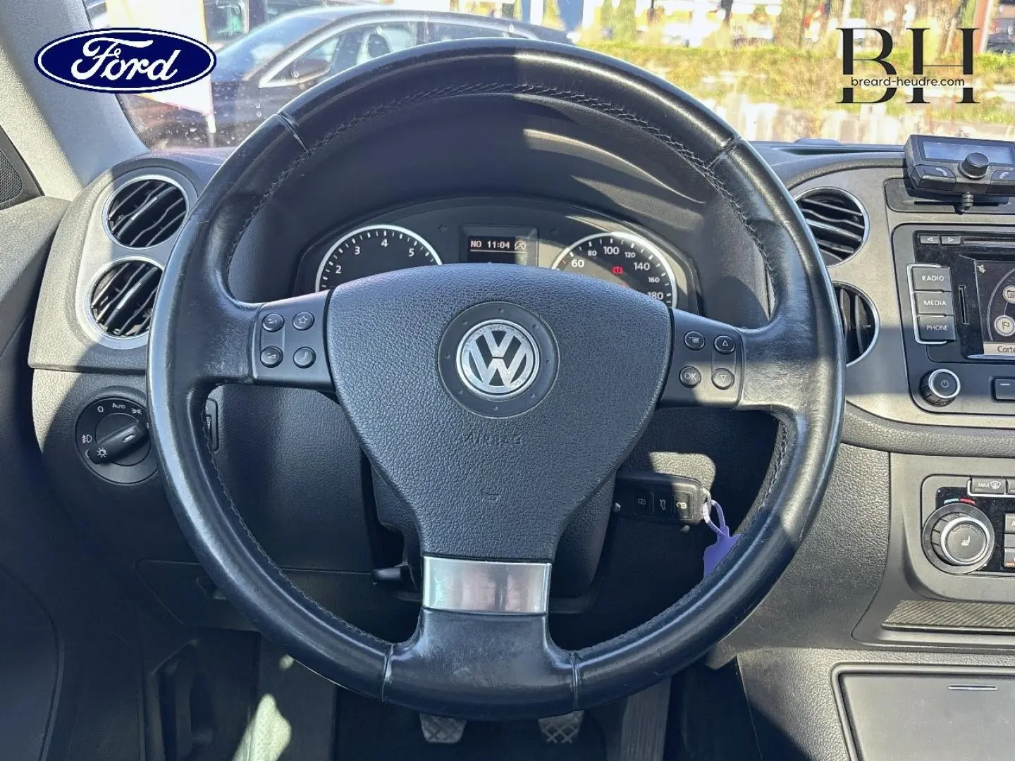 Vue rapprochée du volant cuir multifonction noir et du tableau de bord d’un Volkswagen Tiguan 2010.