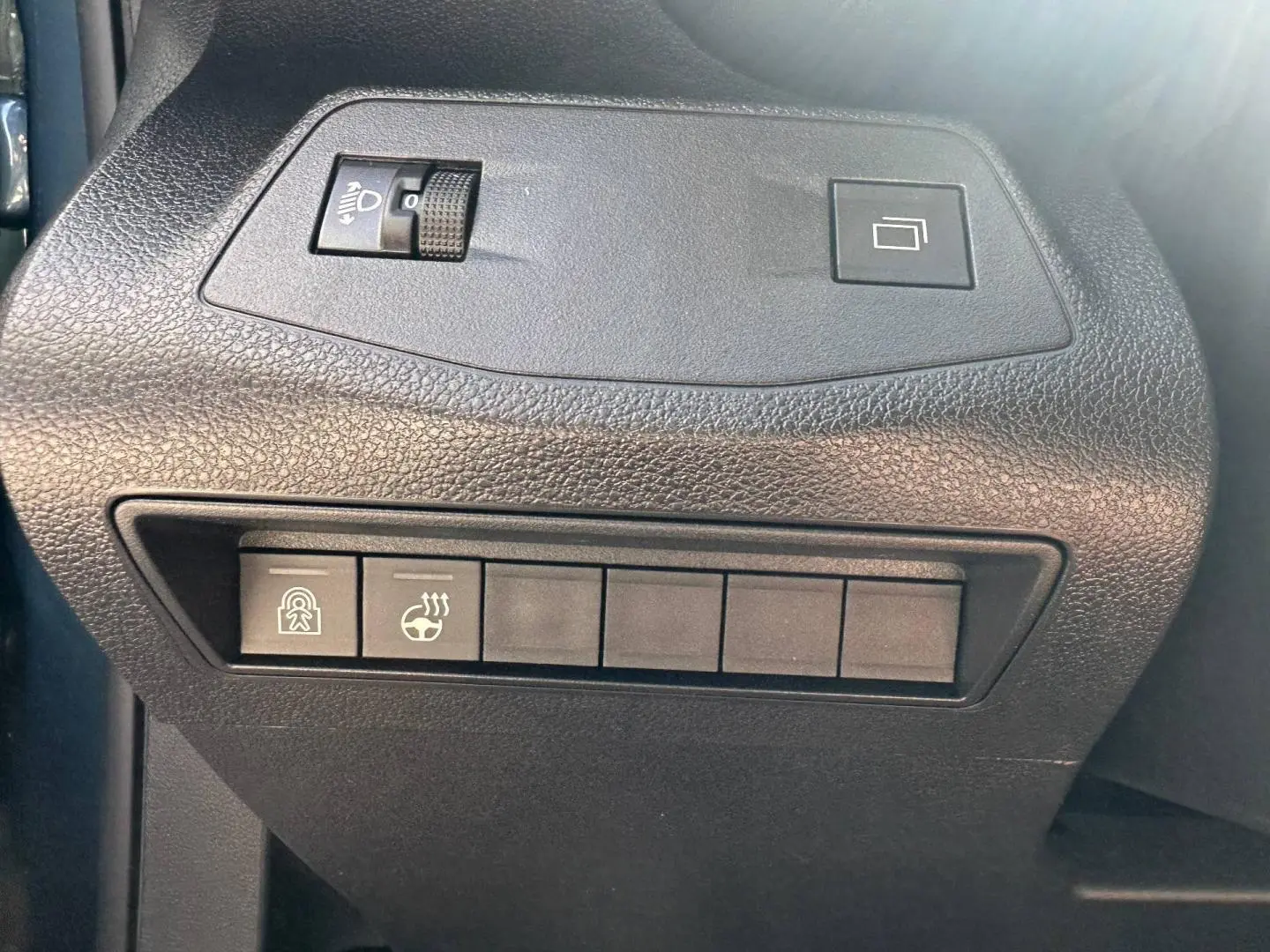 Vue rapprochée des commandes noires sur la gauche du tableau de bord du Citroën Berlingo Kiama Blue 2026.