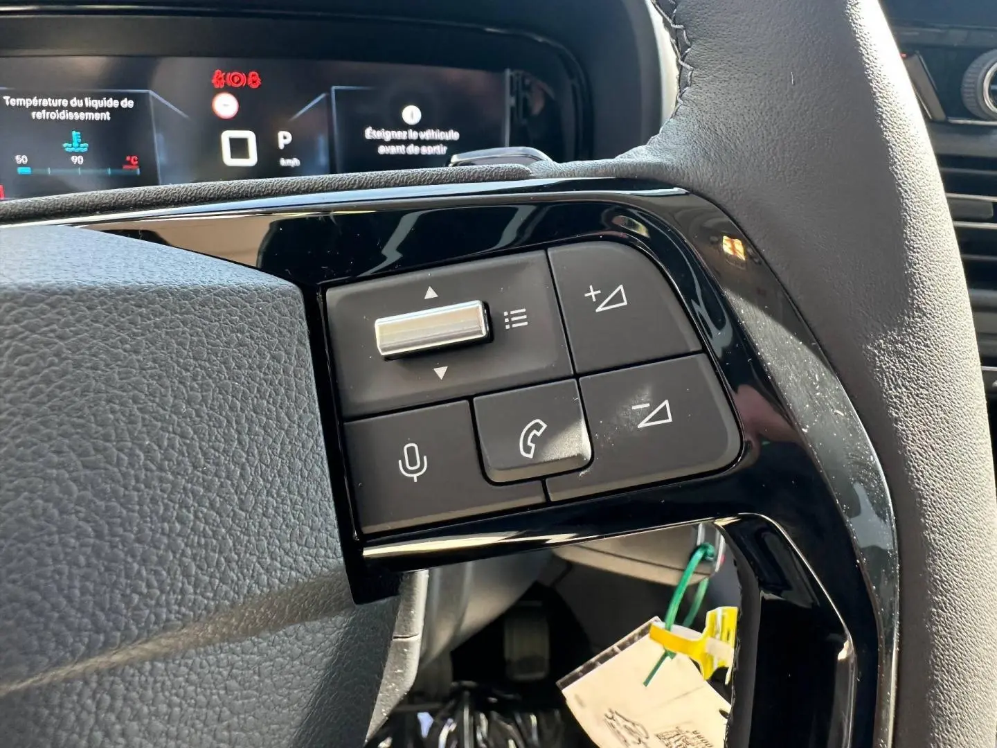 Gros plan sur les commandes multifonctions noires du volant cuir du Citroën Berlingo 2026, version BlueHDi.