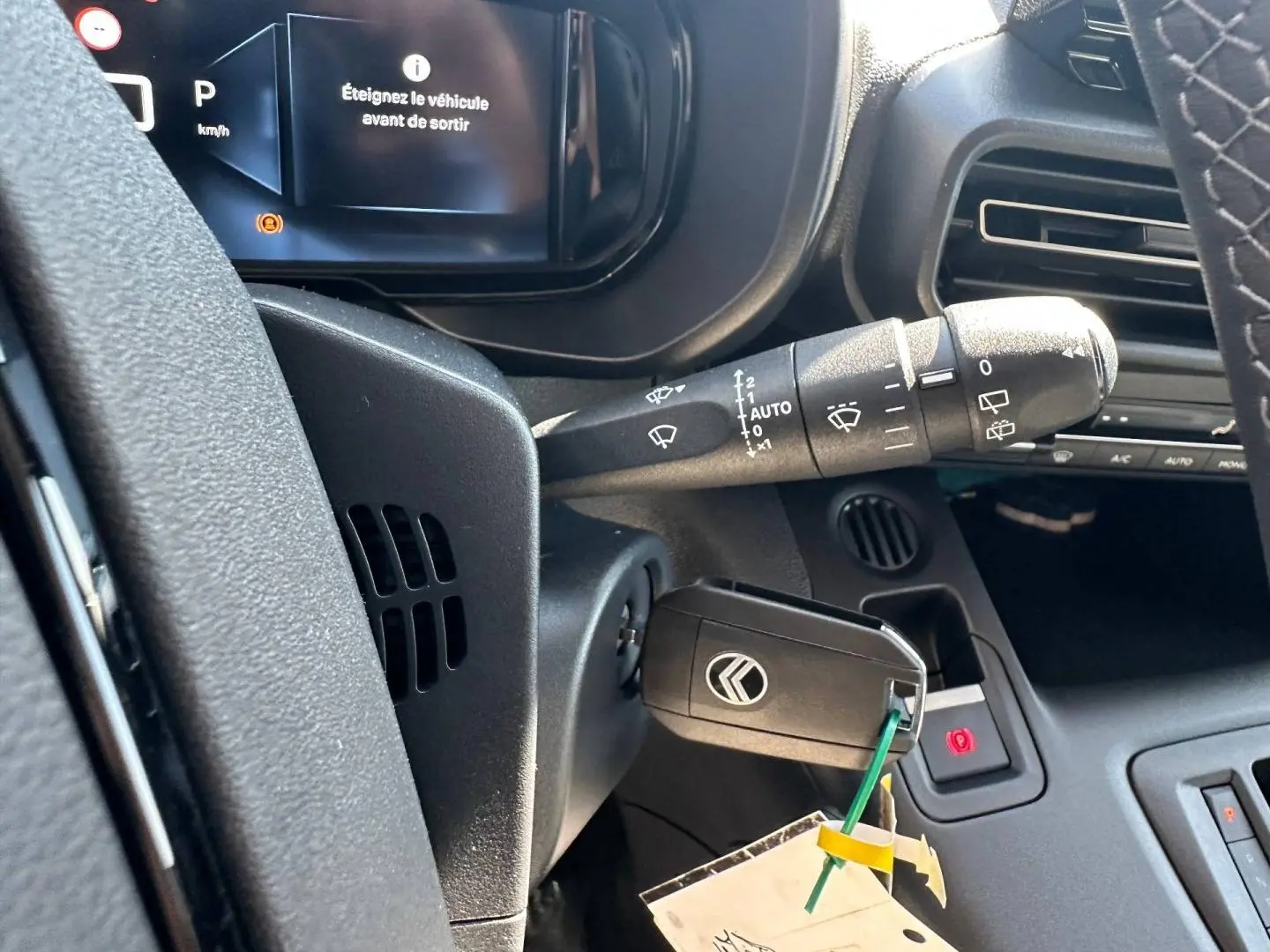 Gros plan sur le tableau de bord et clé de contact du Citroën Berlingo 2026, affichage digital et commandes noires.