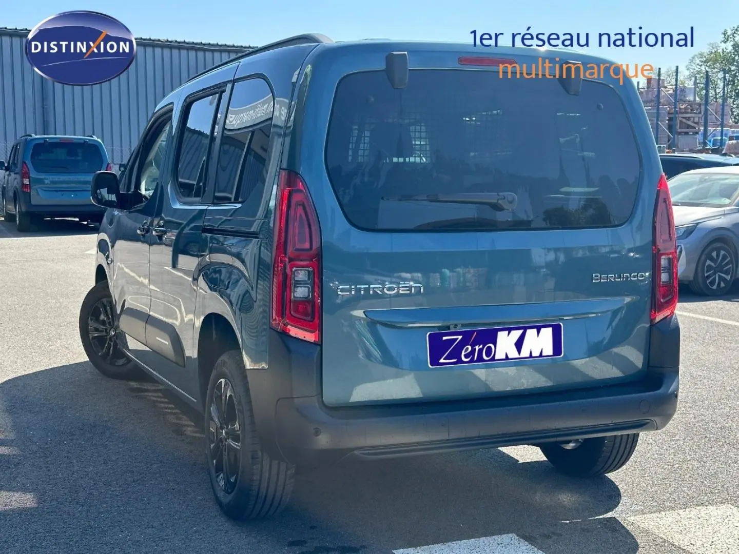 Vue 3/4 arrière droite du Citroën Berlingo 2026 en Kiama Blue avec barres de toit et vitres teintées.
