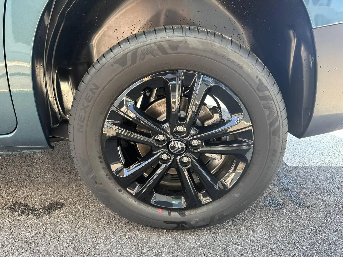 Gros plan sur la jante noire brillante et le pneu Nexen du côté avant gauche du Citroën Berlingo Kiama Blue.