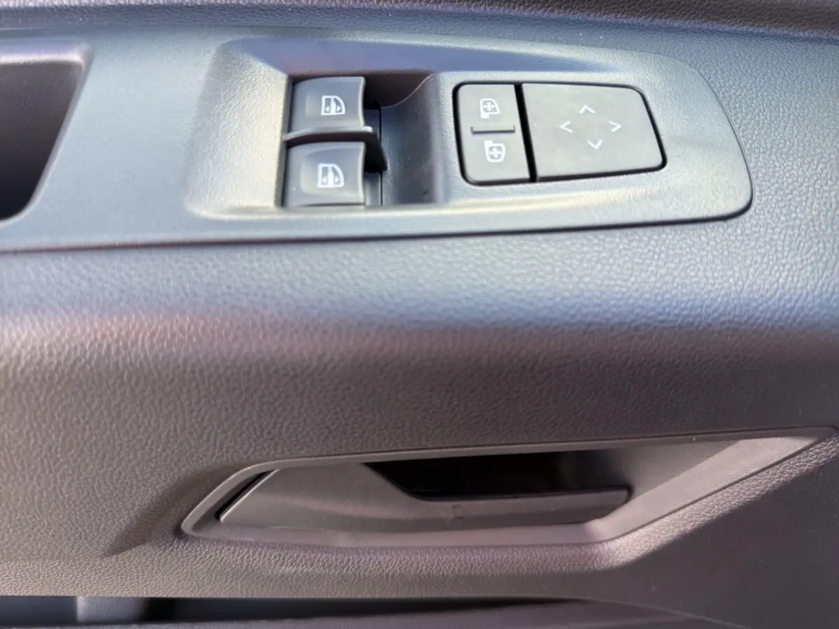 Gros plan sur les commandes de vitres et rétroviseurs électriques côté conducteur du Renault Master gris intérieur.