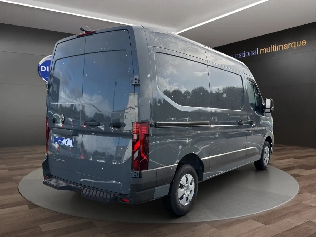 Vue 3/4 arrière droite d’un Renault Master gris foncé avec portes arrière pleines et feux arrière LED, stationné en intérieur.