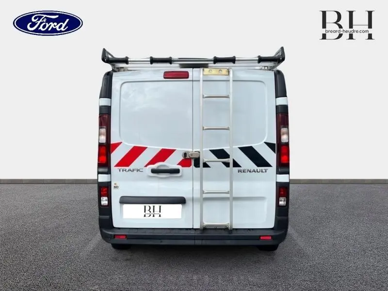 Vue arrière d’un Renault Trafic Fourgon blanc glacier avec galerie de toit aluminium et échelle métallique.
