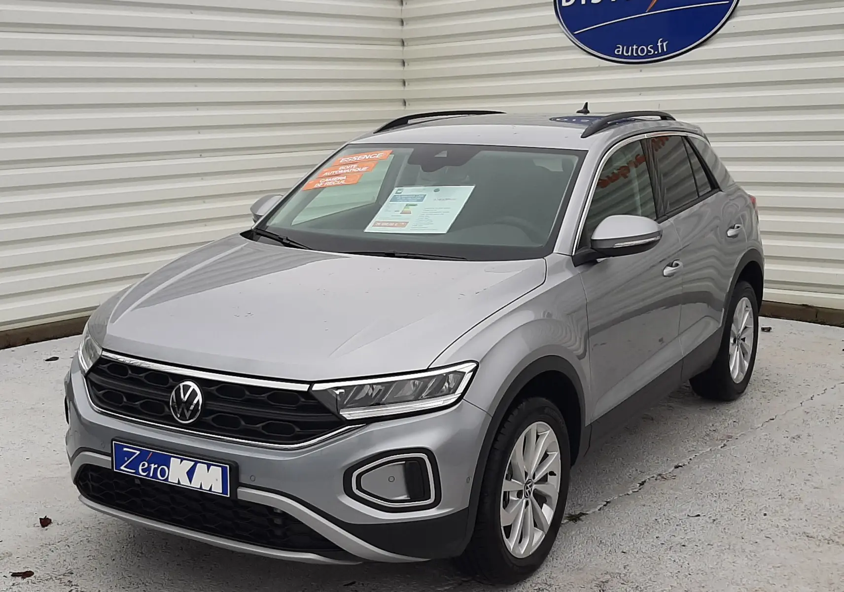 Volkswagen T-Roc gris pyrite métal en 3/4 avant droit, avec calandre noire et toit ouvrant visible.