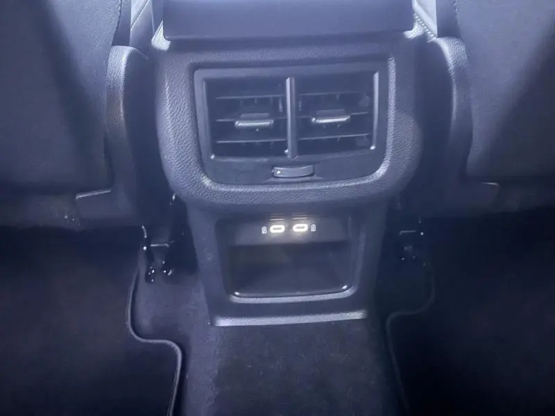 Vue rapprochée des prises USB-C et des aérateurs arrière noirs dans l'habitacle du SEAT Ateca noir Magique Métal.