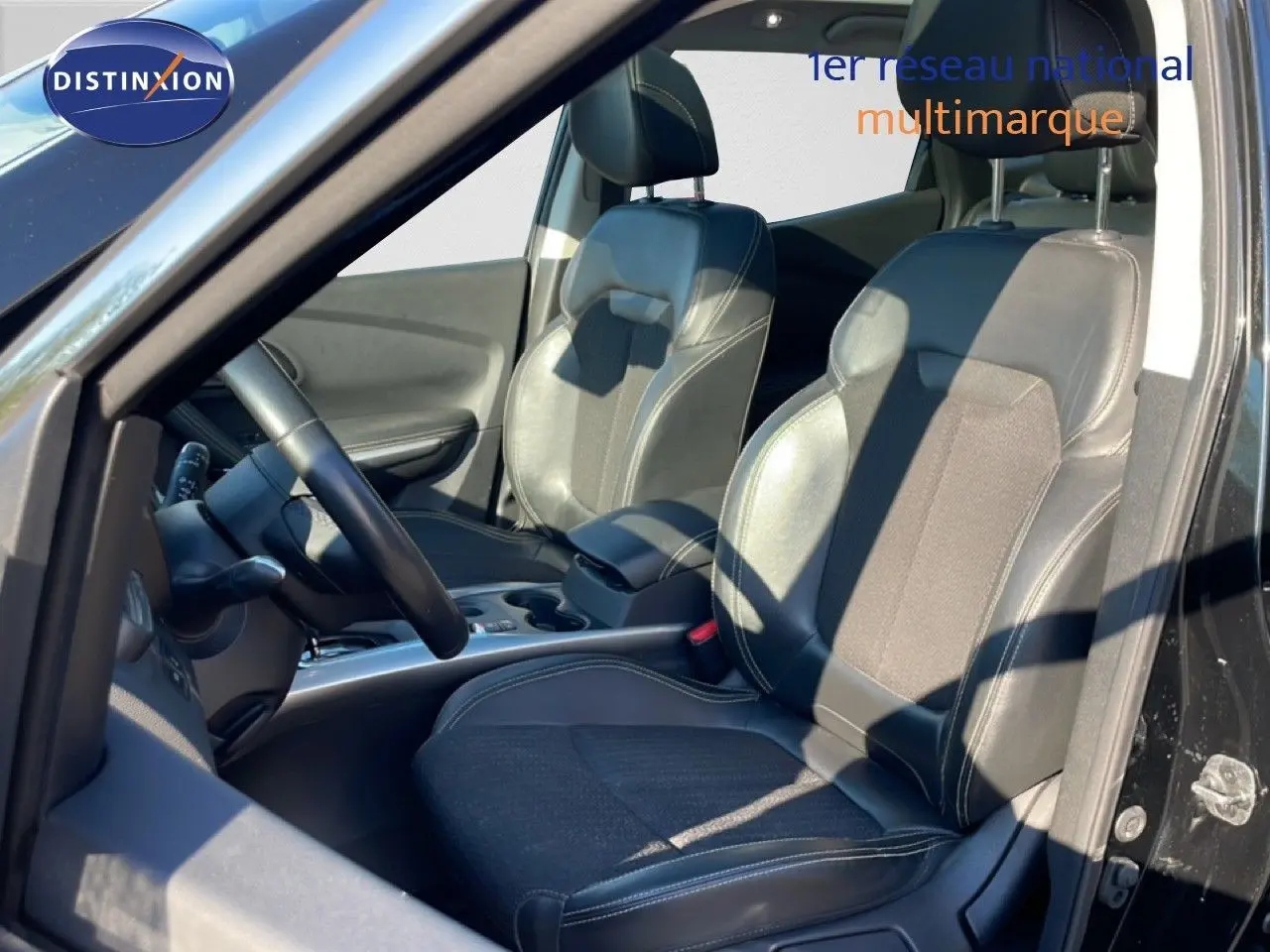 Vue intérieure côté conducteur du Renault Kadjar noir 2018, montrant les sièges en tissu et cuir ainsi que le volant.