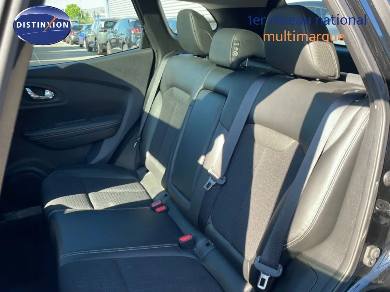 Vue intérieure côté gauche des sièges arrière noirs du Renault Kadjar 2018 avec ceinture de sécurité et porte ouverte.
