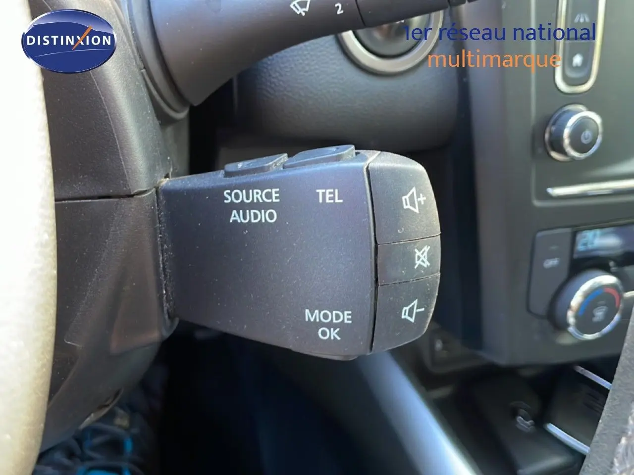 Gros plan sur la commande audio au volant du Renault Kadjar noir, mettant en valeur les boutons source, téléphone et mode.