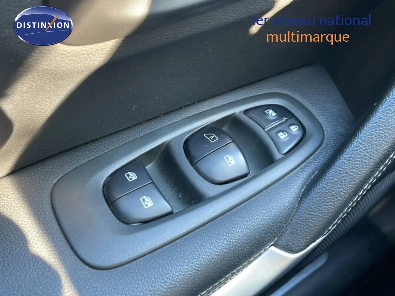 Gros plan sur les commandes des vitres électriques côté conducteur d'un Renault Kadjar noir, intérieur en cuir noir.