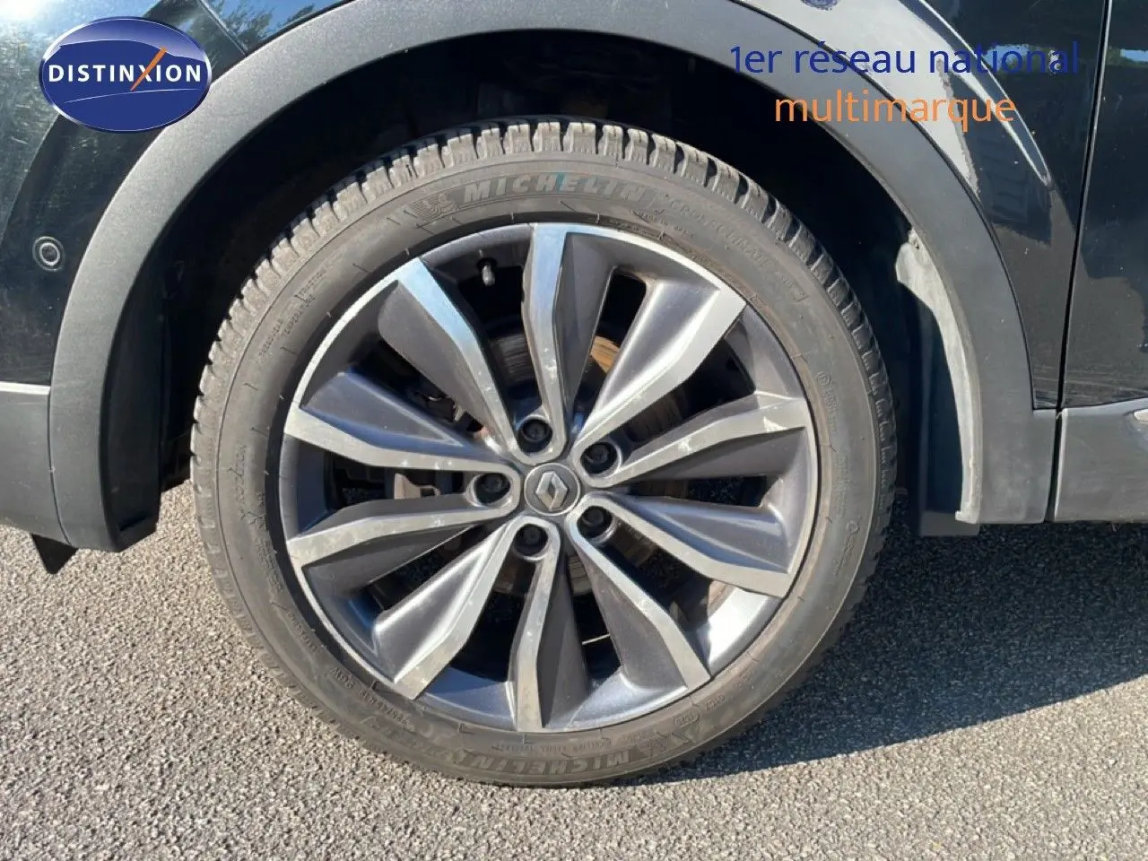 Gros plan sur la roue avant gauche noire d’un Renault Kadjar 2018 avec jante alliage gris foncé.