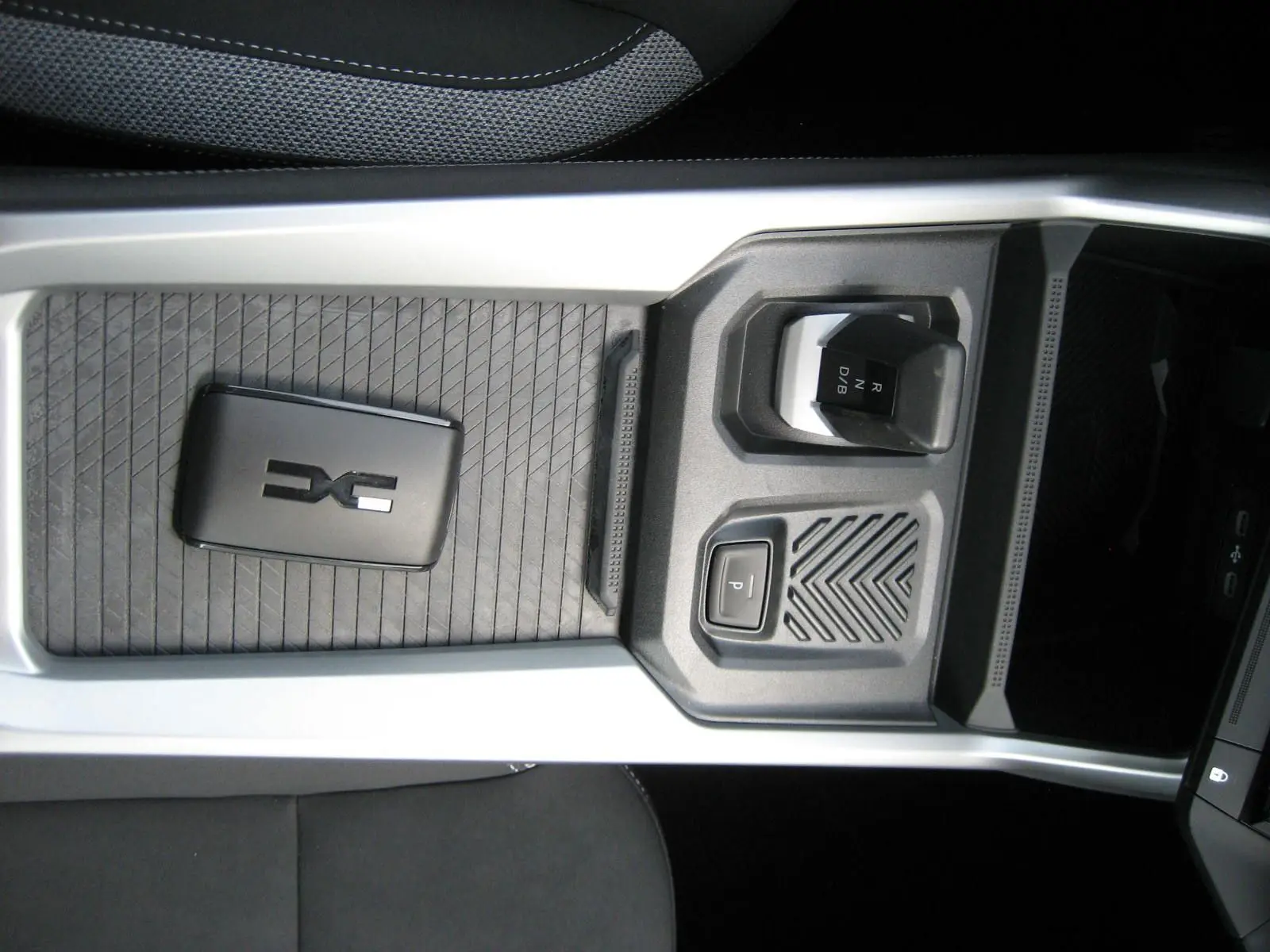 Vue rapprochée de la console centrale noire du Dacia Bigster 1.8 Hybrid 155 ch avec levier de vitesses automatique.