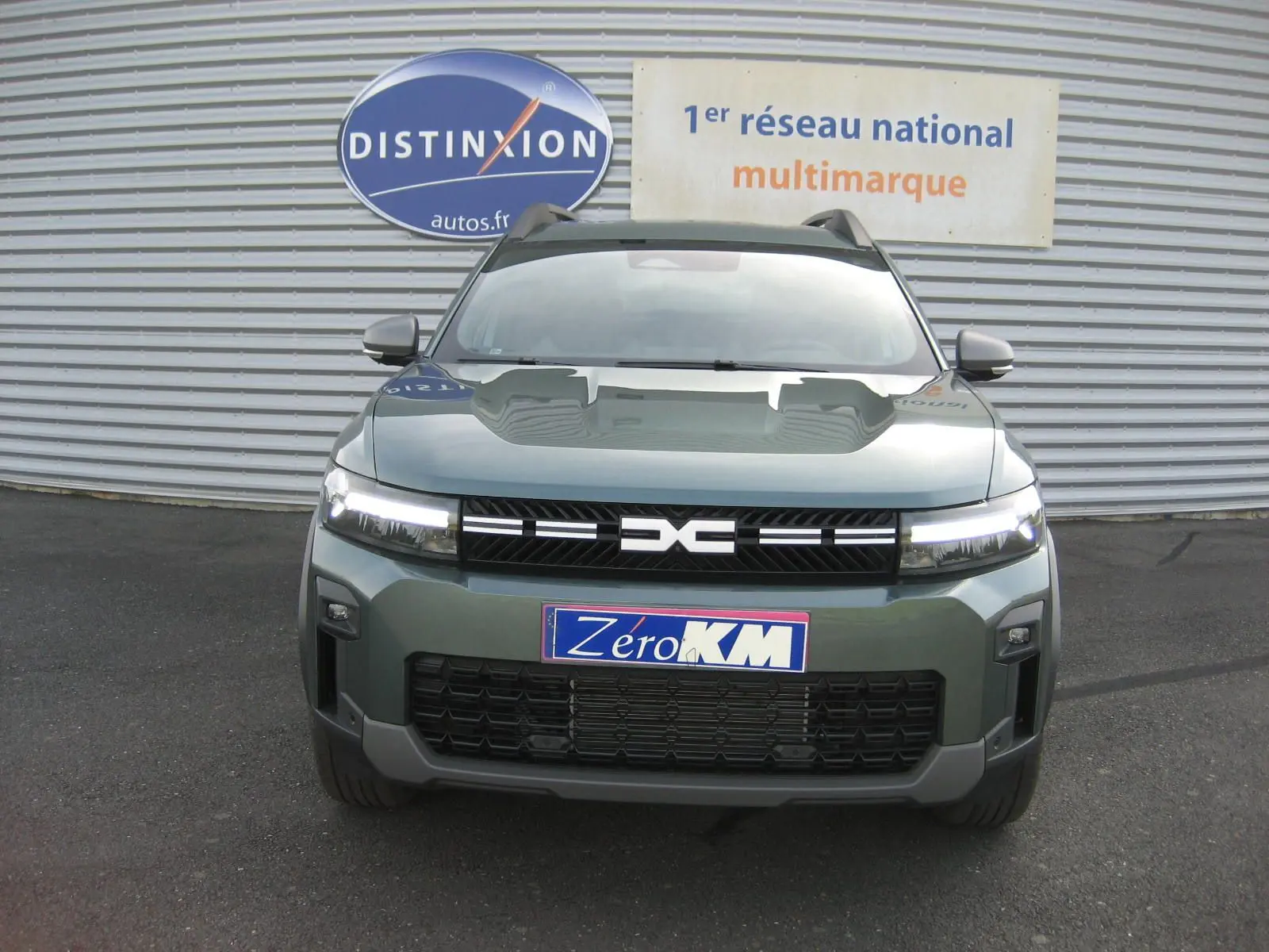 Vue frontale du Dacia Bigster gris schiste 2026 avec calandre noire et phares LED allumés.