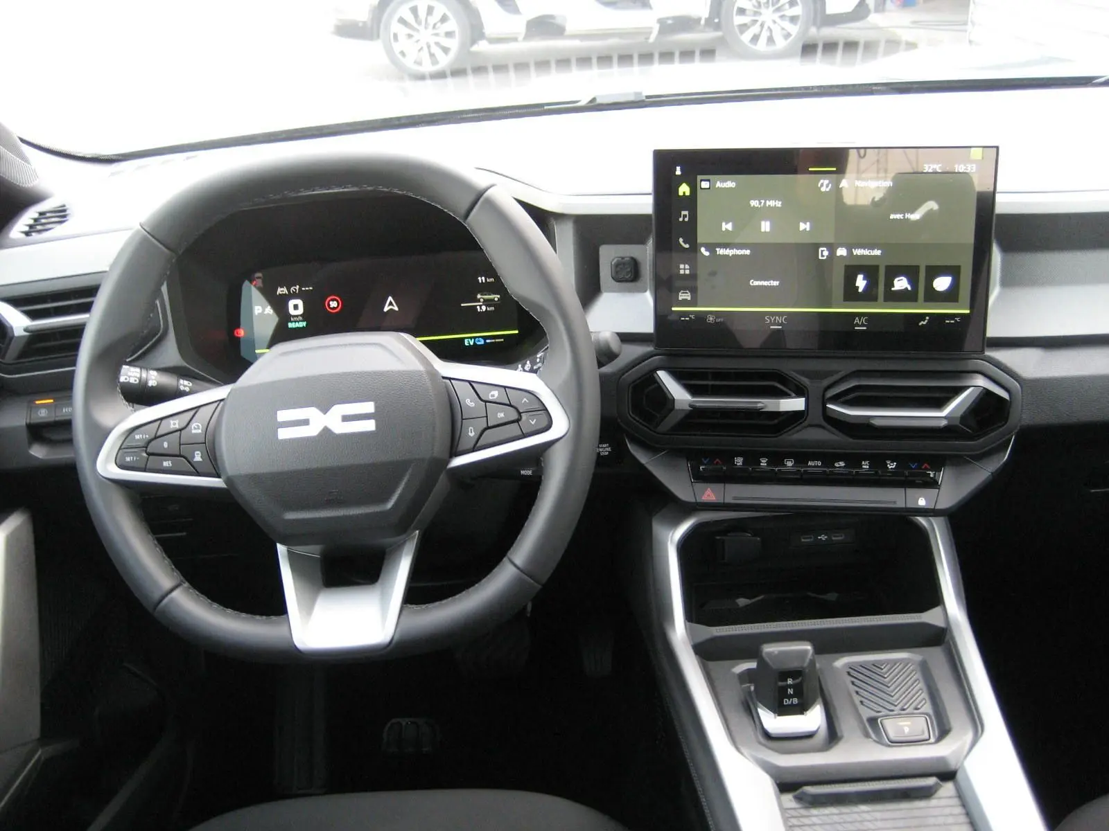 Vue intérieure centrée sur le volant et la console centrale du Dacia Bigster 2026, avec écran tactile et commandes modernes.