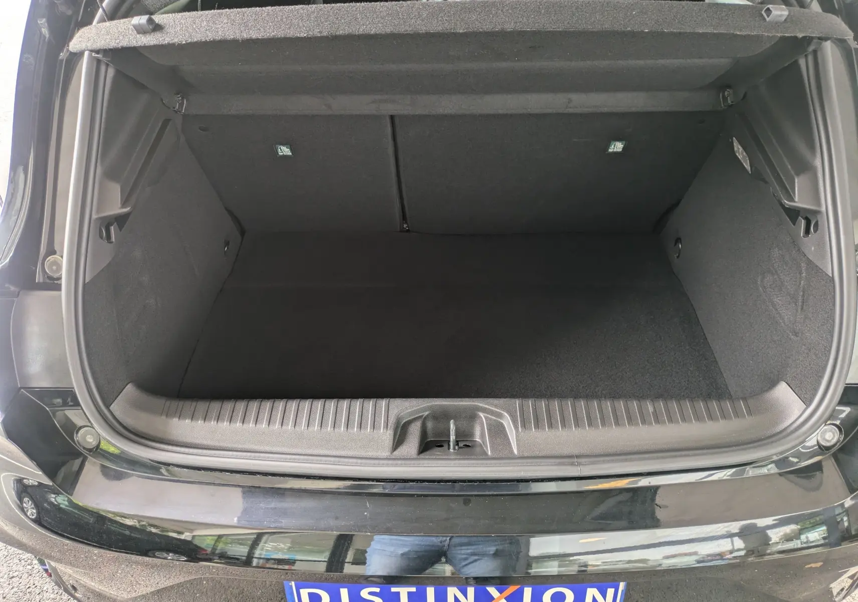 Coffre ouvert vu de dessus d'une Renault Clio noire étoile métal 2025, intérieur de coffre spacieux et propre.
