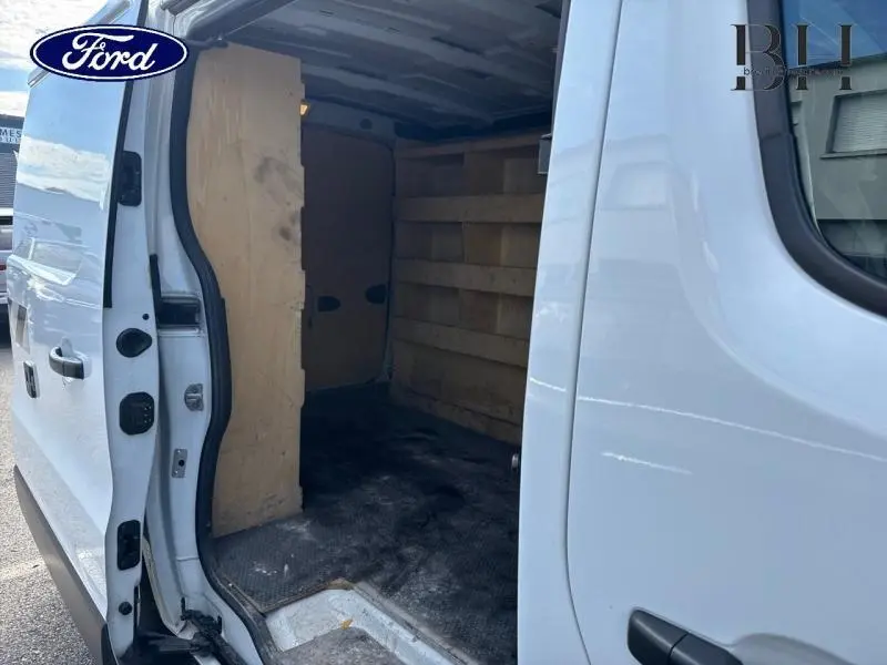 Vue latérale droite d’un fourgon blanc avec porte coulissante ouverte, montrant l’intérieur habillé de bois.
