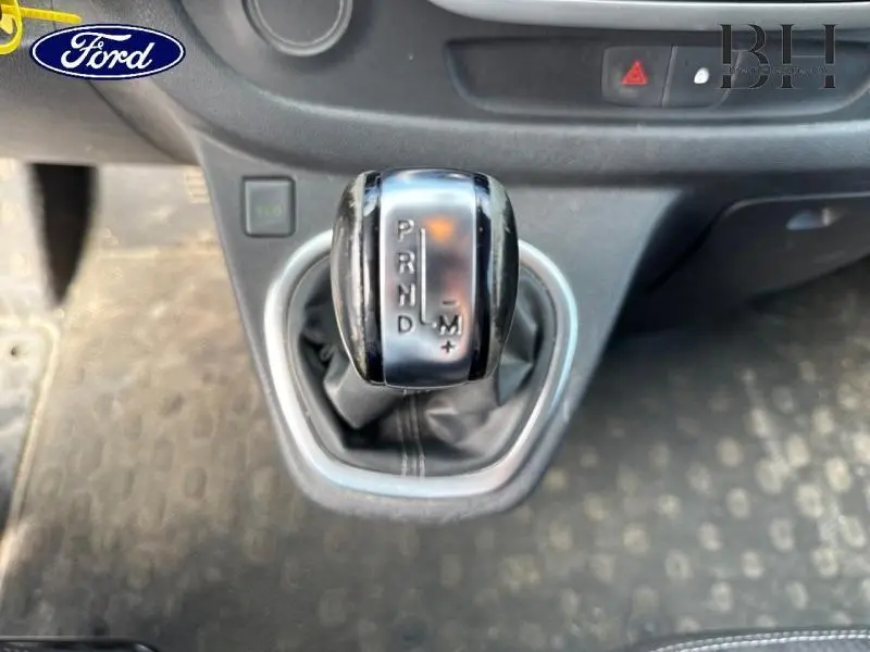 Le levier de vitesses automatique en gros plan dans l'habitacle du Renault Trafic blanc, avec indication des modes P, R, N, D et M.
