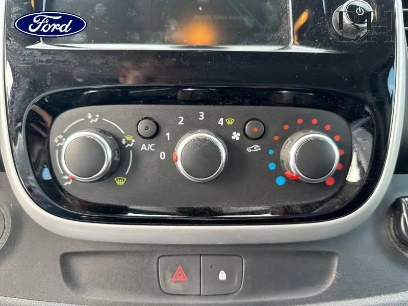 Panneau de commande de climatisation noir du Renault Trafic Fourgon blanc, vue rapprochée du tableau de bord central.
