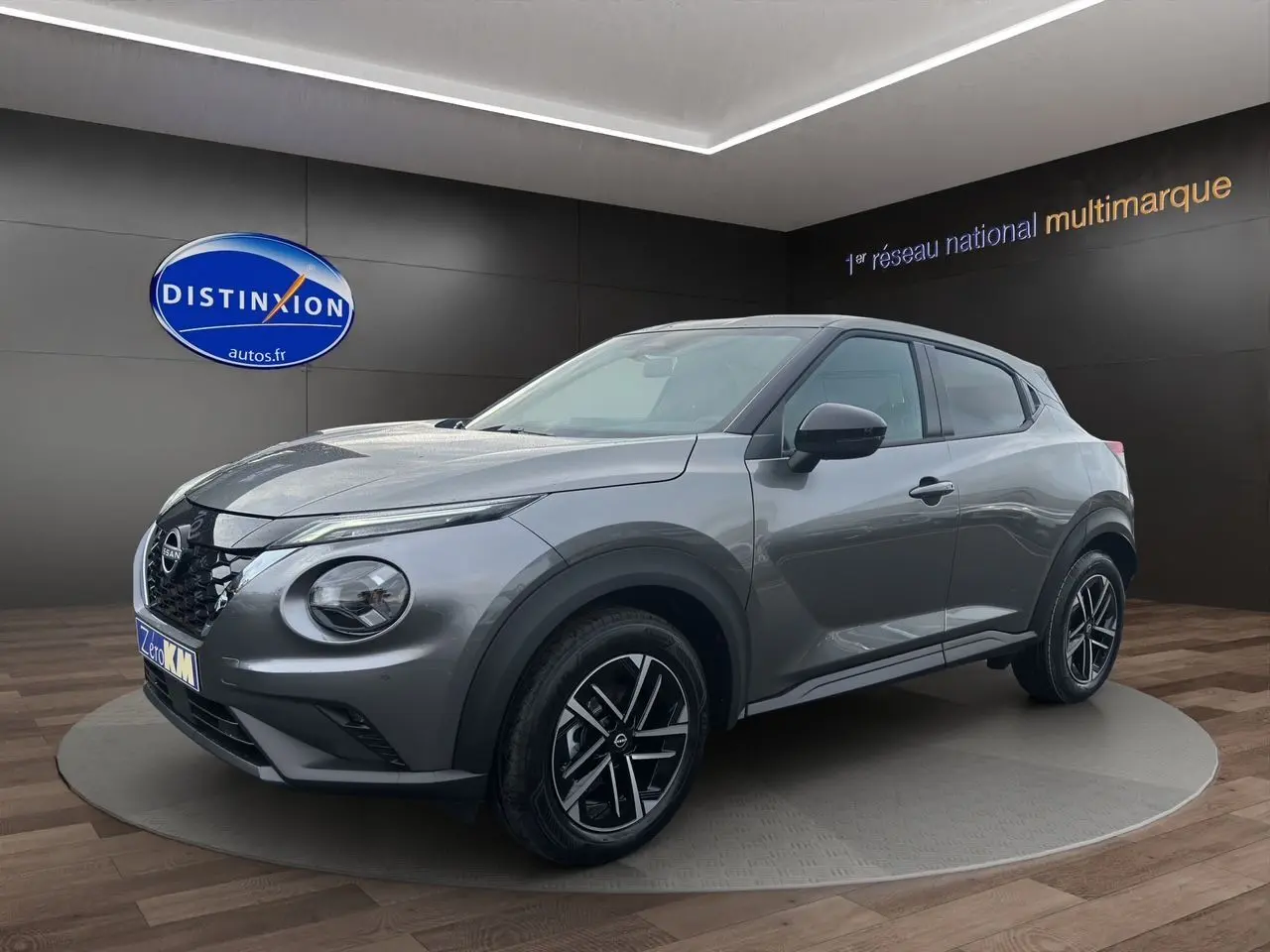 Nissan Juke 1.6 Hybrid 2025 gris squale en 3/4 avant droit, avec jantes noires et détails modernes distinctifs.