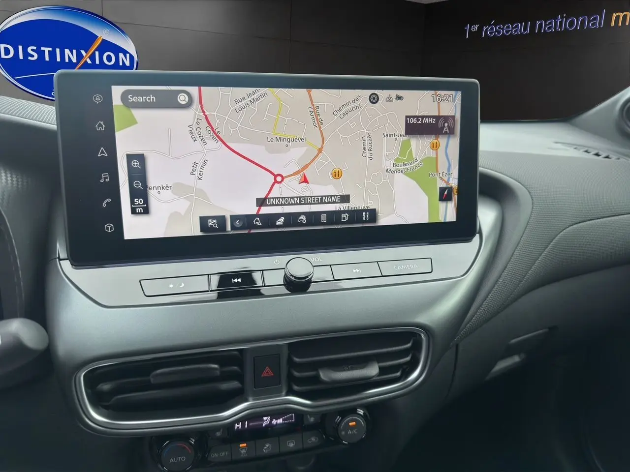 Vue intérieure centrée sur l'écran tactile du tableau de bord du Nissan Juke 1.6 Hybrid gris Squale, version 2025.