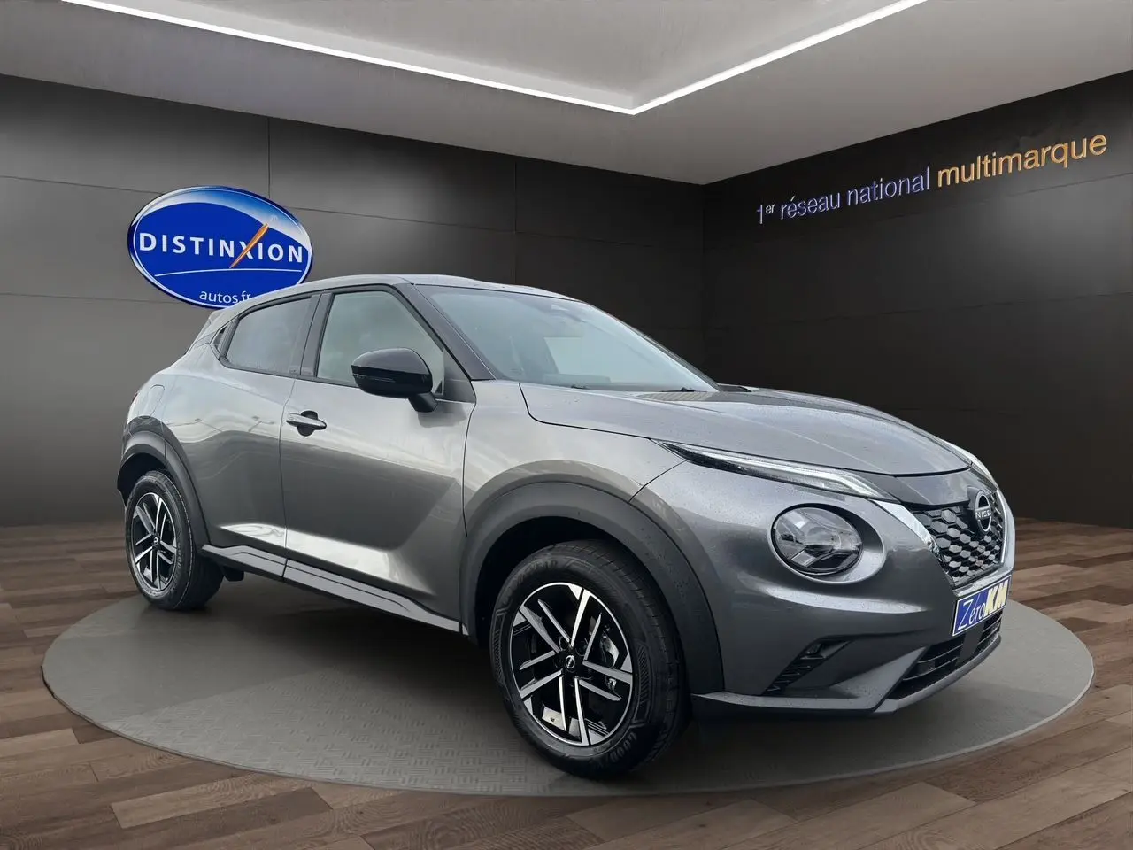Nissan Juke 2025 gris squale en 3/4 avant droit, avec jantes noires et détails noirs contrastants.